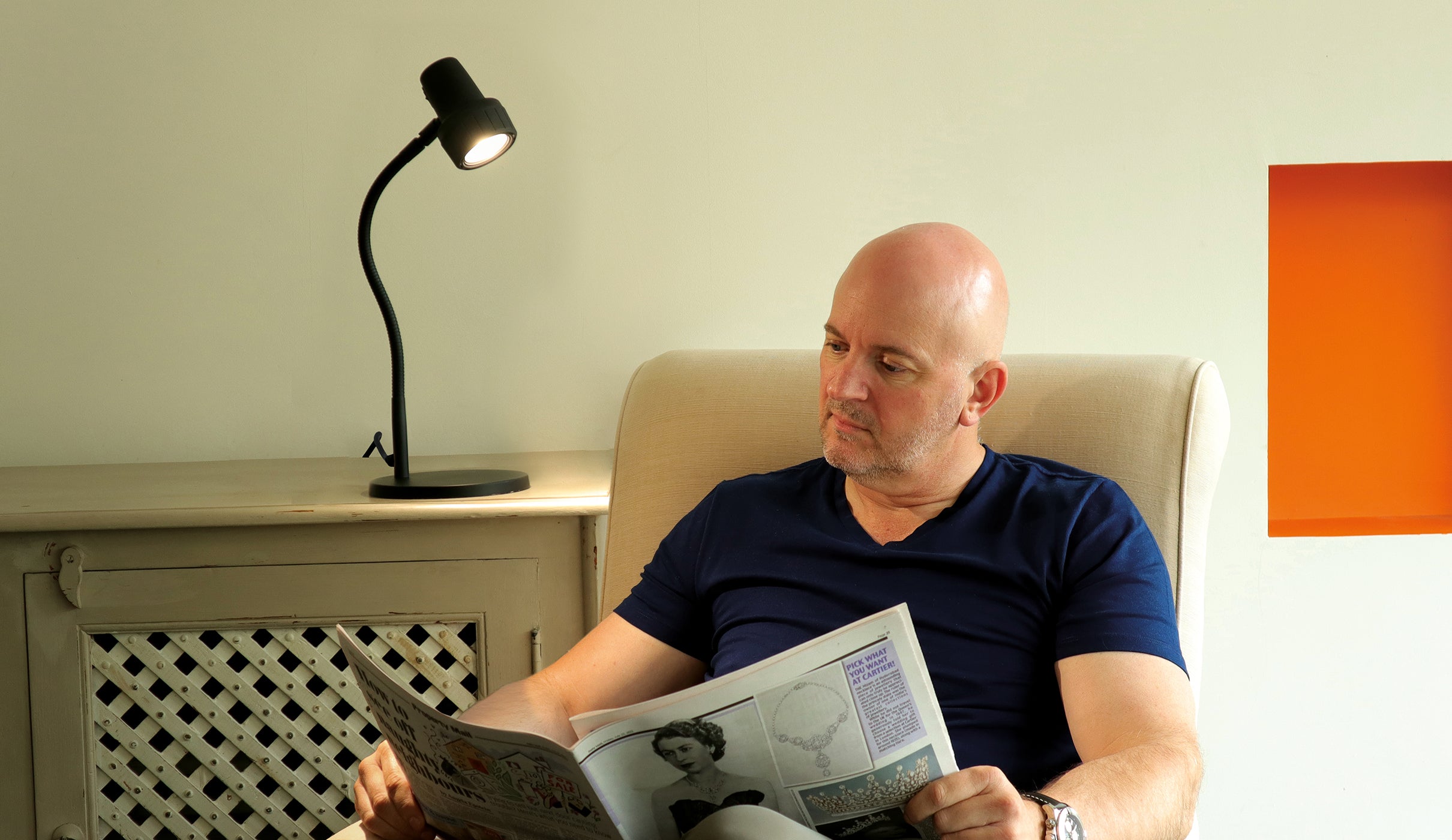 Man with Compact Light reading in armchair
